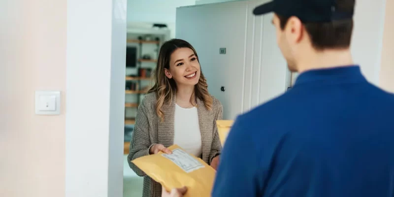 Happy woman taking package from knighthak courier delivery boy